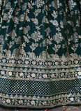 Close-up of a dark green fabric with intricate silver floral embroidery