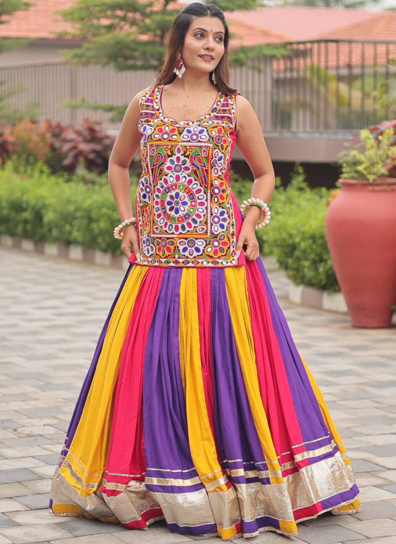 Woman wearing a colorful traditional outfit with a patterned top and multicolored skirt.