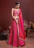 Rani pink chinon silk lehenga choli for party functions with printed dupatta. This indian designer pink lehenga is beautified with thread sequence embroidery work and its also comes with banglory silk real mirror thread embroidery work pink choli. This pink lehenga choli was completed with designer chinon silk bandhej print shaded dupatta.